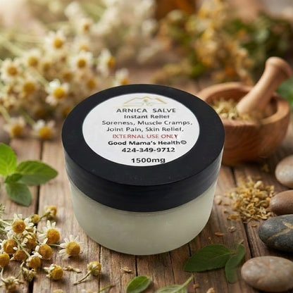 Jar of Arnica Salve with a label on a wooden surface with herbs and flowers.